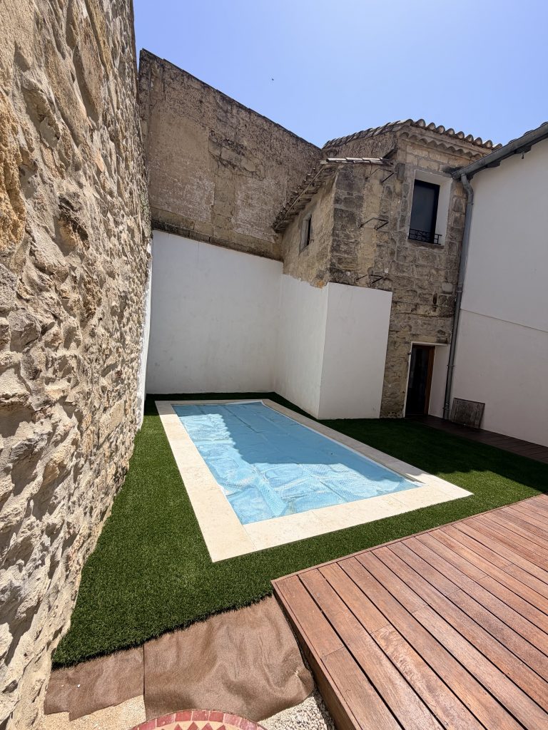 Gazon synthétique autour d'une piscine en patio