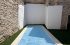 Gazon synthétique autour d'une piscine en patio