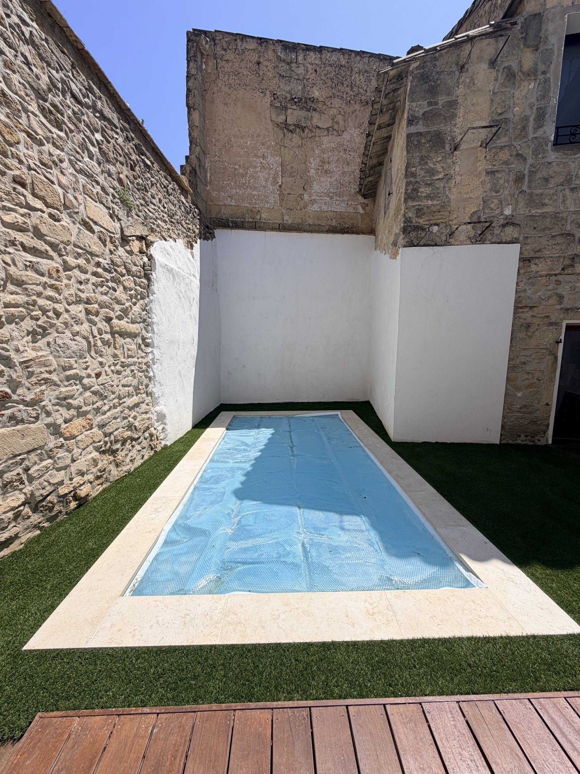 Gazon synthétique autour d'une piscine en patio